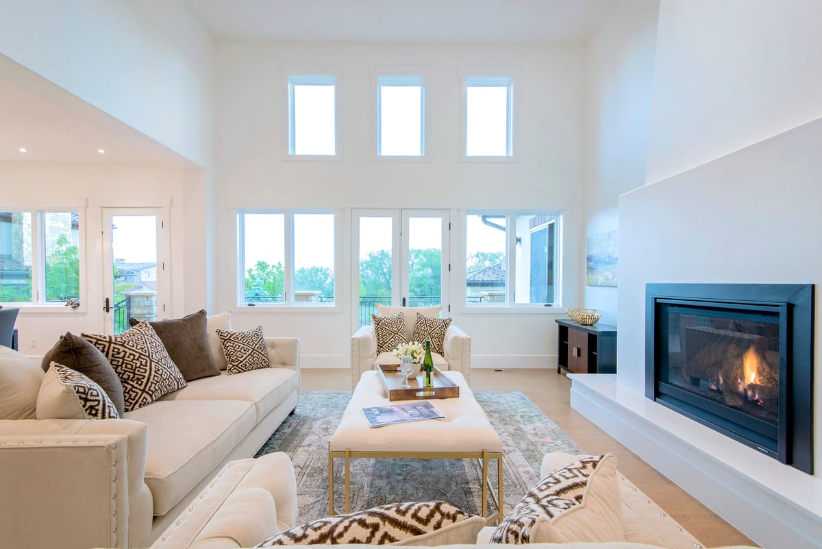 A tall living room with a gas fireplace and clerestory windows