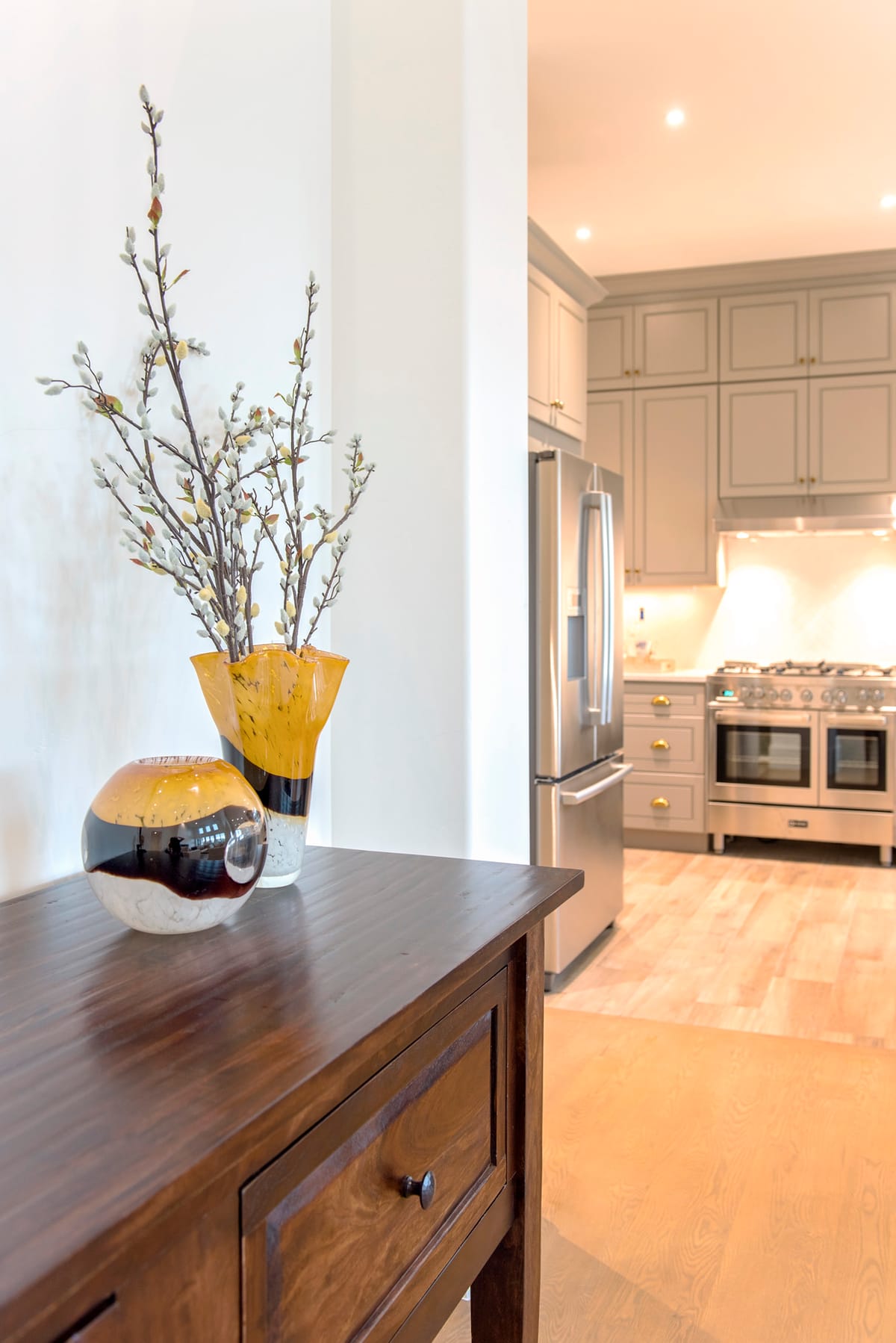 A hallway console with a vase, looking through to the kitchen