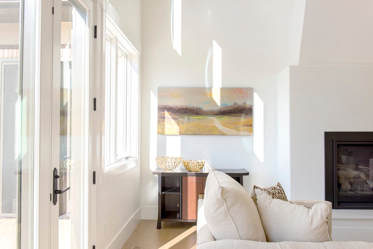 A sitting area beside a fireplace, with tall windows and a French door