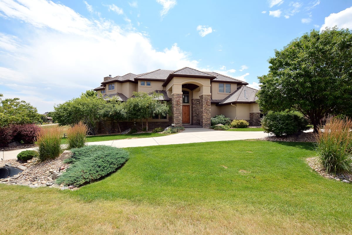 The home behind a curving lawn and shrub border