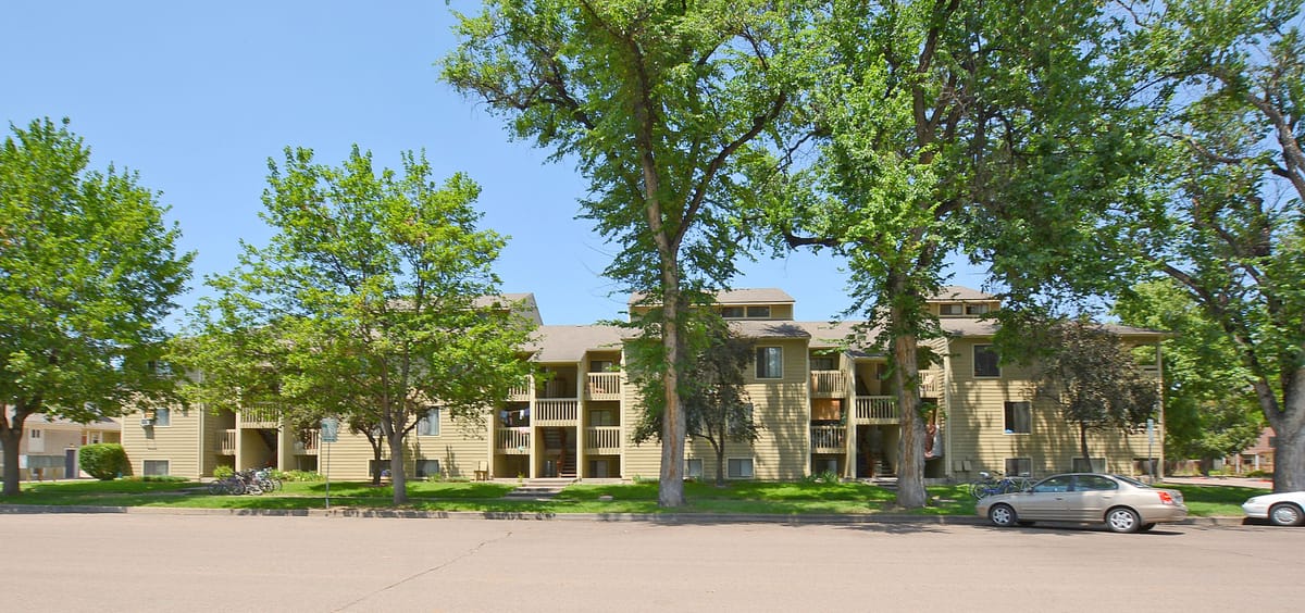 The apartment building from the street, framed by cottonwoods