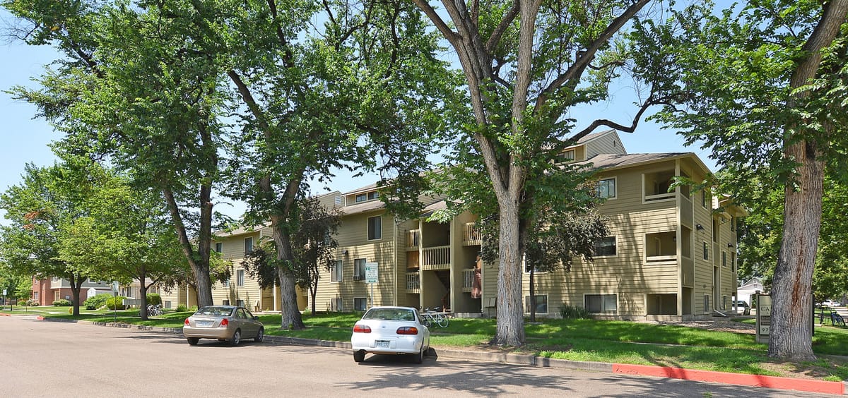 A wing of the apartment building with parking along the front