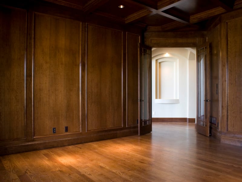A panelled study in dark wood with a coffered ceiling