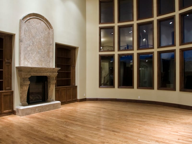 A great room with a stone fireplace and a wall of windows