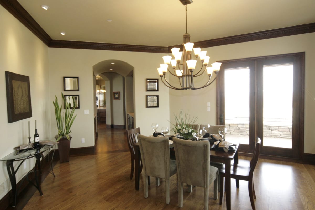 A dining room with a chandelier over a table set for eight