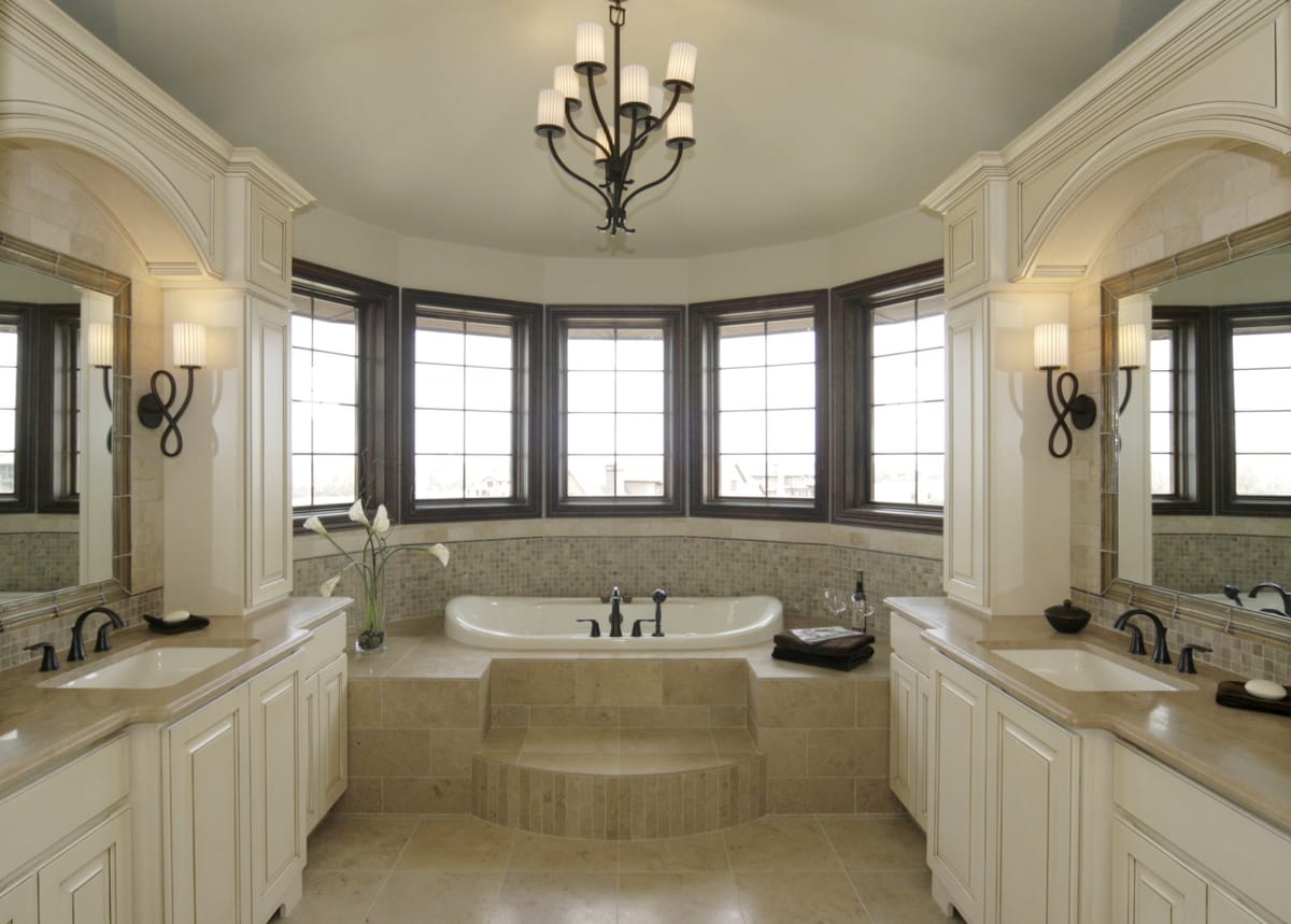 A main bathroom with a corner tub below a bay of windows
