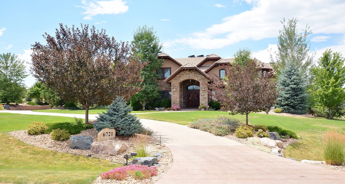 The home behind a circular drive and mature landscaping