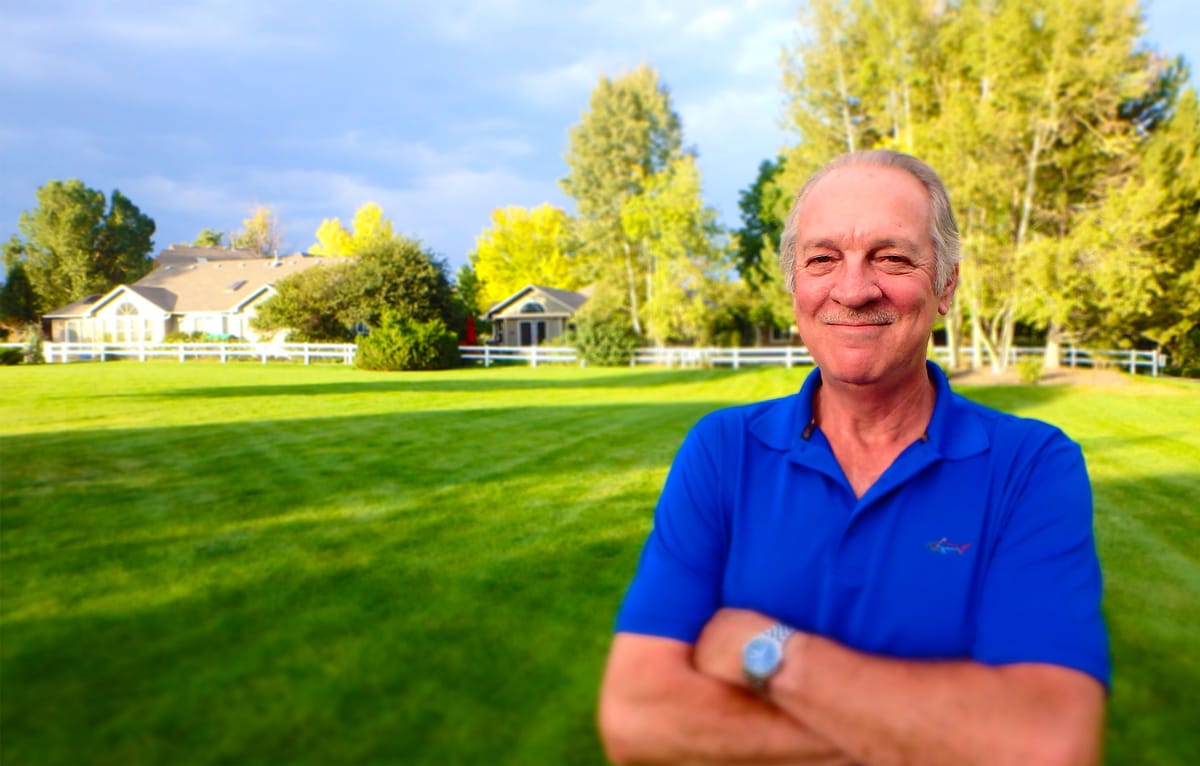 Dale Terrel standing on a lawn in front of a row of houses