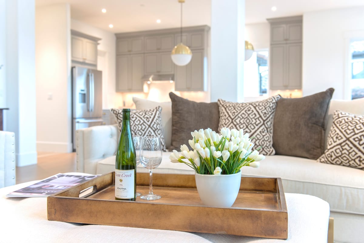 A bright open-plan living room with a serving tray of flowers and glasses