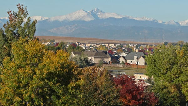 Longs Peak seen across the rooftops of Greeley in autumn